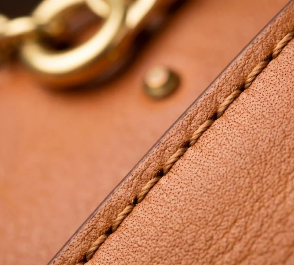 Gros plan sur les détails d'un sac de luxe vintage en cuir avec coutures et fermoir métallique, mise au point sélective